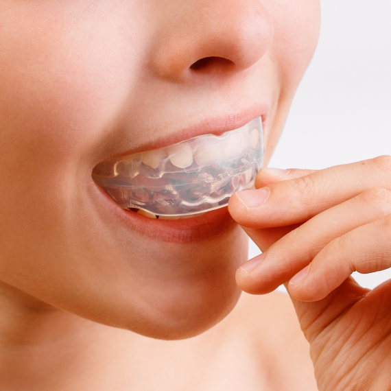 Patient holding up a dental shade guide guide to her teeth